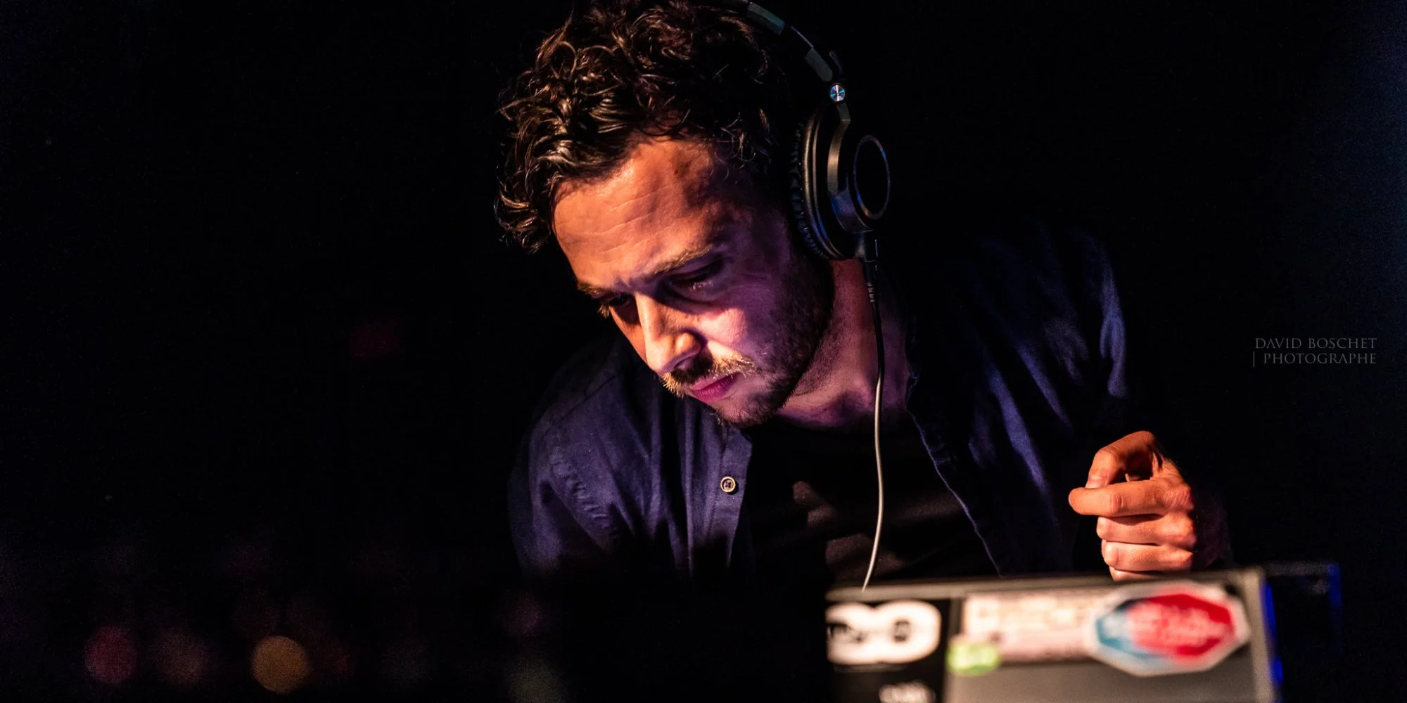Another shot of guest DJ Camille Rodriguez wearing headphones and looking down whilst performing.