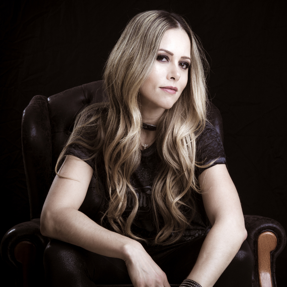 Brazilian DJ and producer Van Storck sitting in a chair looking at camera, colour image.