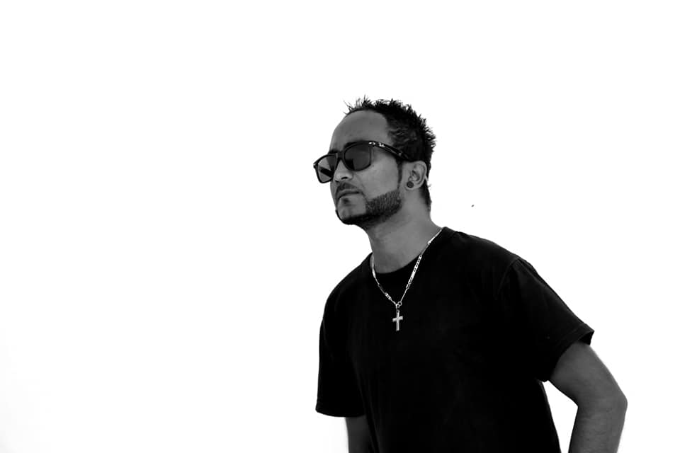 Sri Lnakan DJ Black Jay wearing sunglasees in upper body shot looking to his right, black and white image.