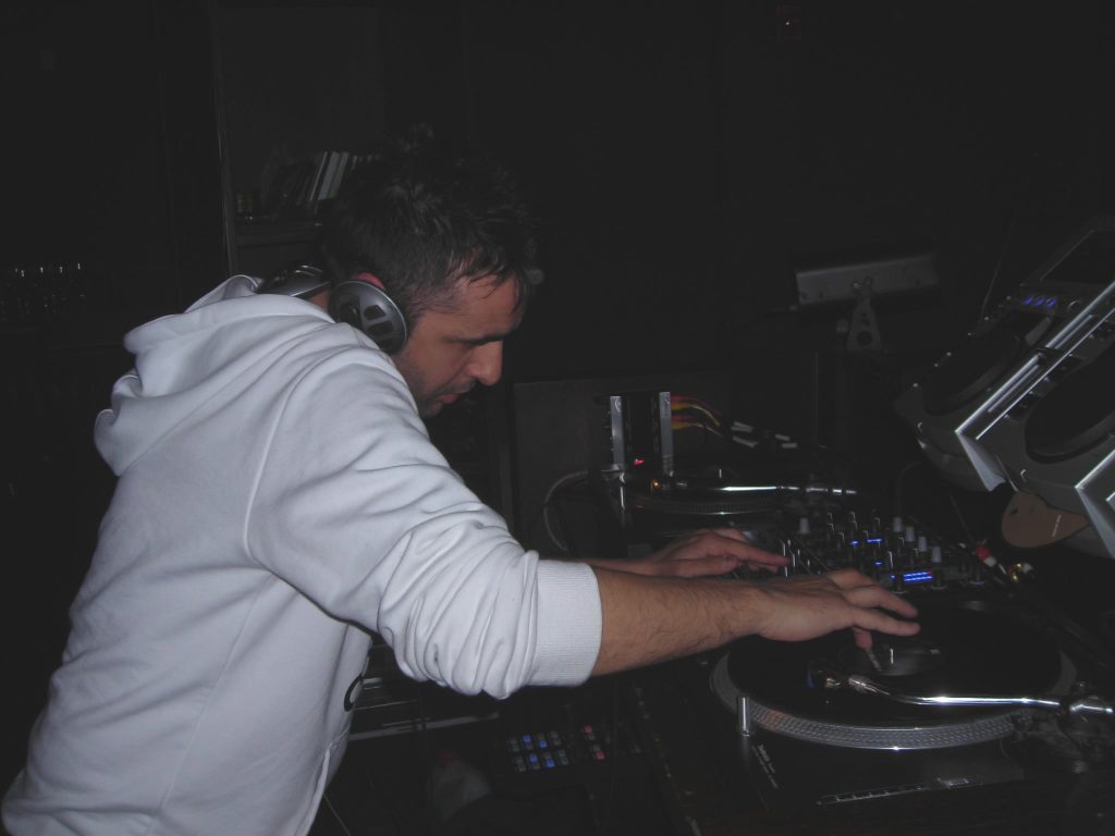 Italian DJ and producer Francesco Conti performing at an event on Technics SL 1210s, colour image.