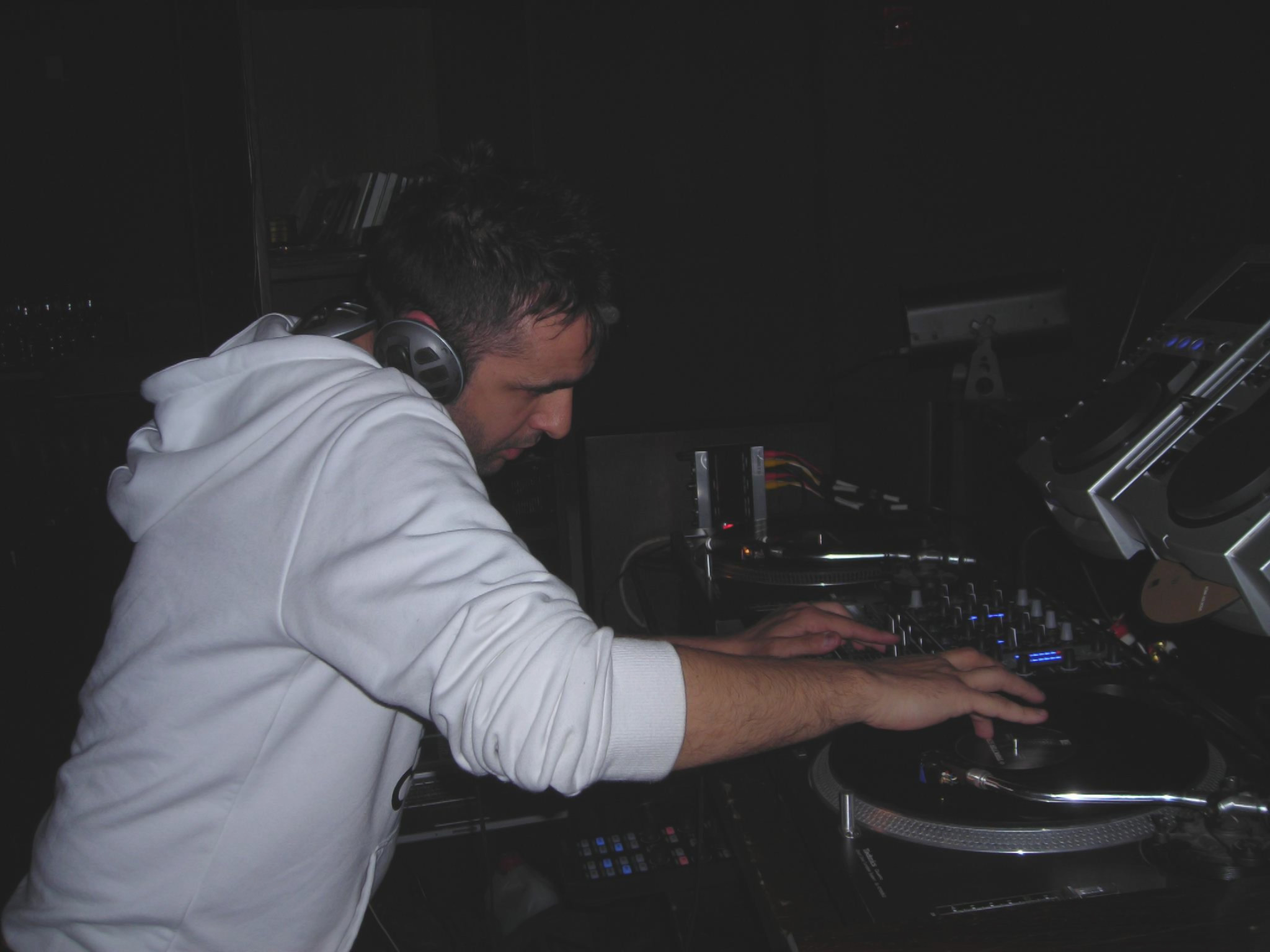 Italian DJ and producer Francesco Conti performing at an event on Technics SL 1210s, colour image.