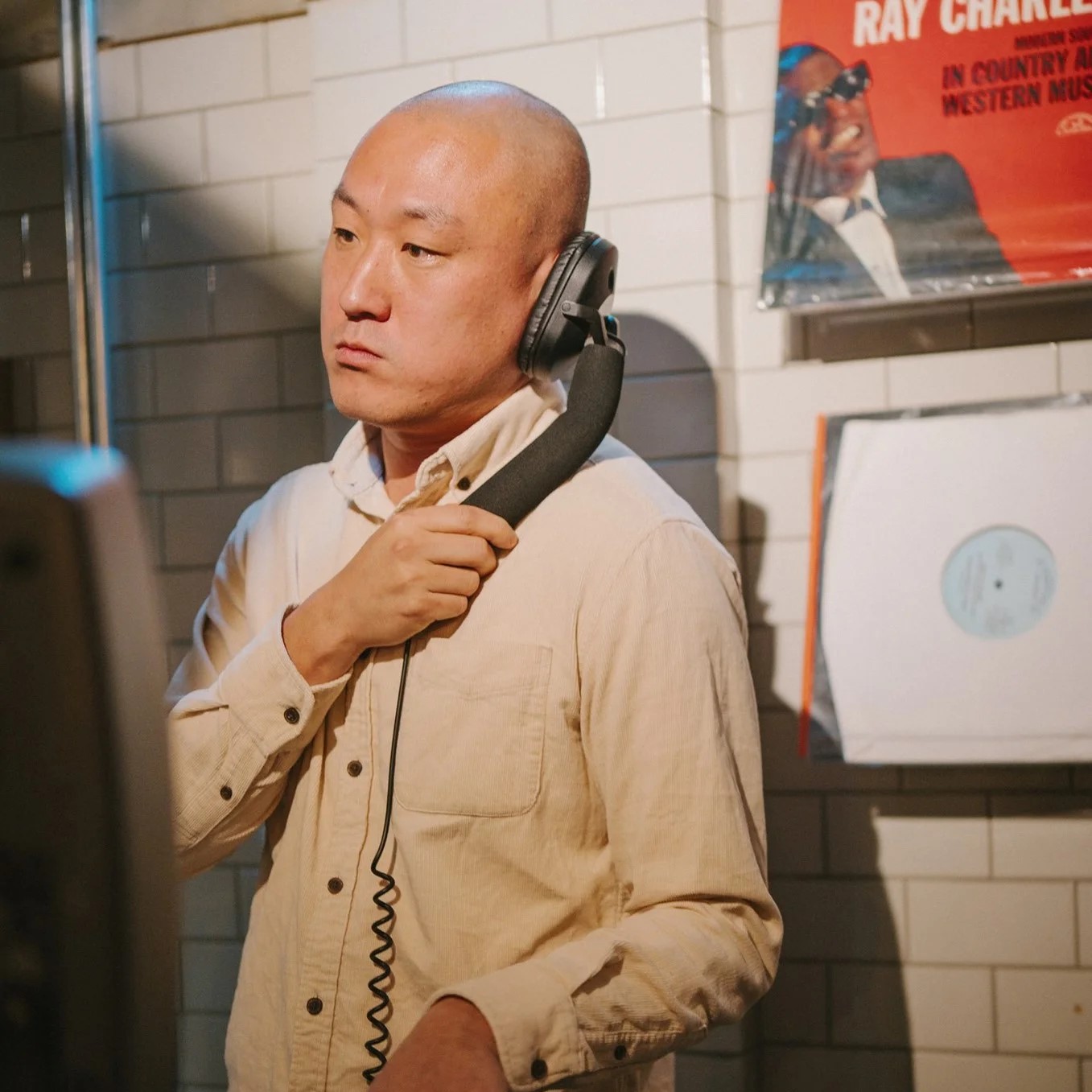taiwanese dj and promoter Murphy Kin a.k.a Dj Lucy performing in a record store and cafe, colour image.
