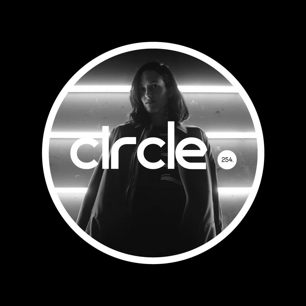 DJ Emmanuella standing behind circle. ibiza 254 logo in black and white.