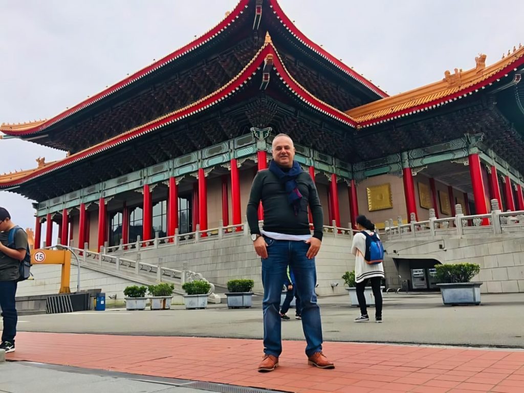 Marco Mei, Italian progressive house DJ and producer, standing in front of a traditional Taiwanese temple in Taipei.