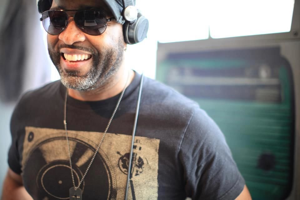 United States of AmericaDJ and producer Darrell Foxx standing wearing headphones, sunglasses and a baseball cap smiling at the camera in upper body shot, colour image.