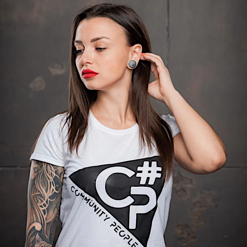 Ukrainian Dj Ksenia Pavlova standing in studio with her left hand on her hair looking over to her right, colour image.