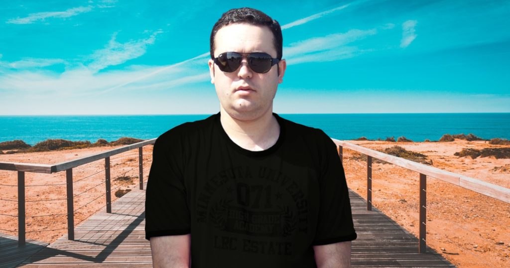 Portuguese DJ Joshua standing on a platform next to the beach, Portugal, colour image.