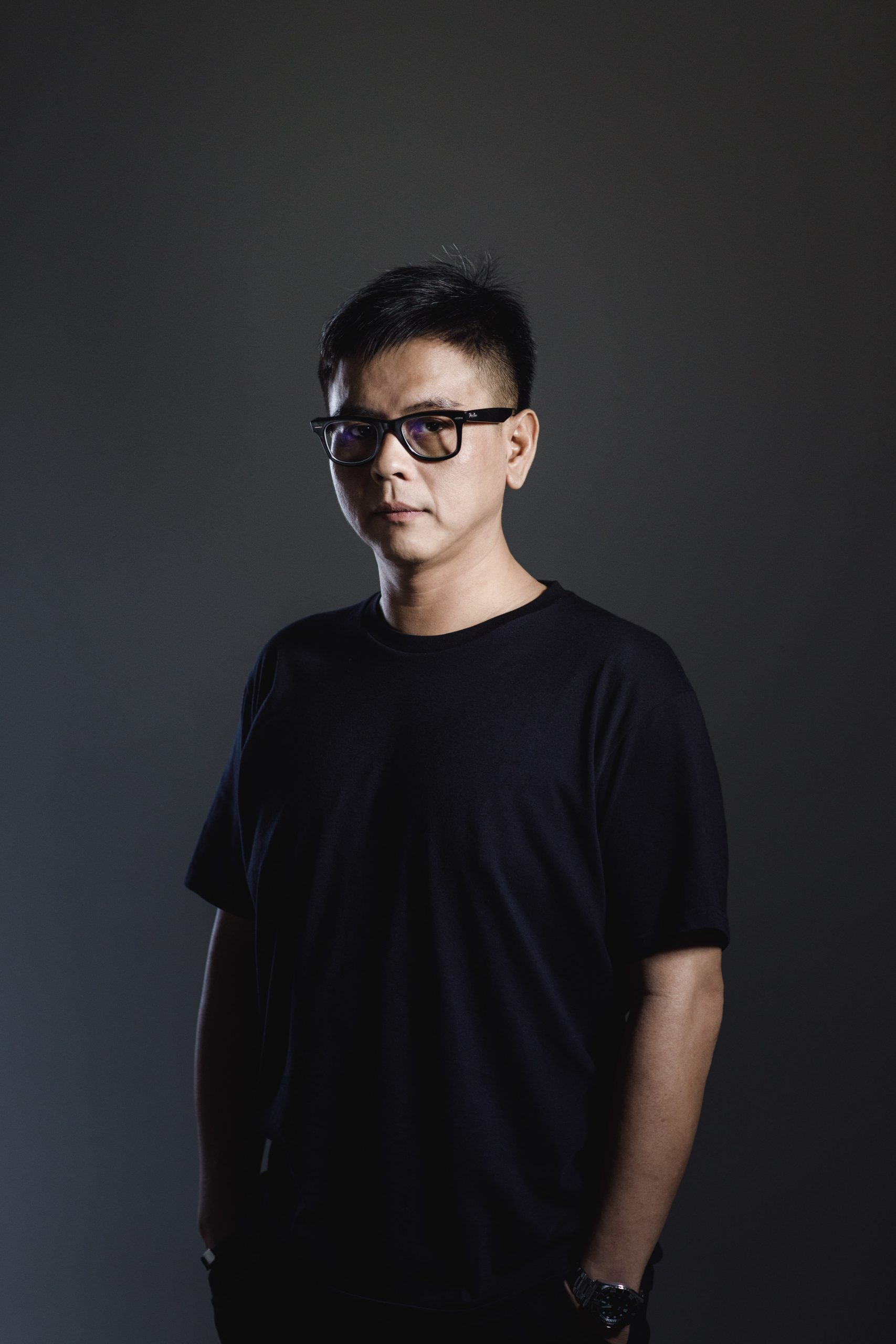 Malaysian DJ and producer Terence C standing with his hands in his pockets in vertical colour image.