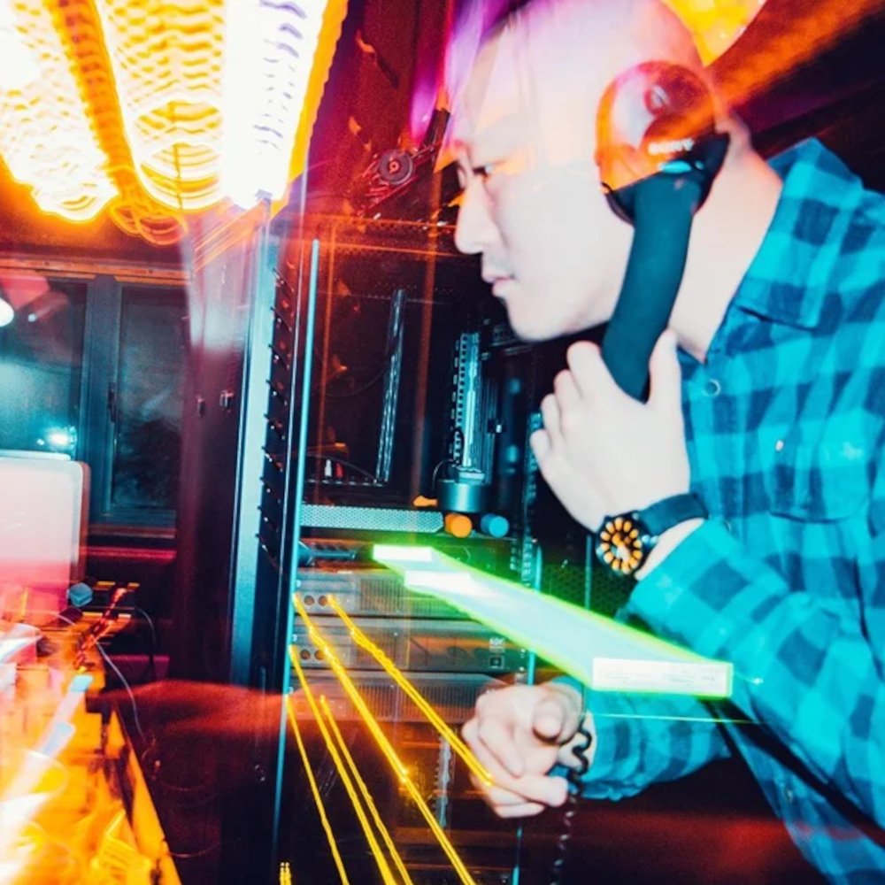 Taiwanese DJ and promoter Murphy Kin a.k.a Dj Lucy performing at an event side photo with timestretch effect, colour image.