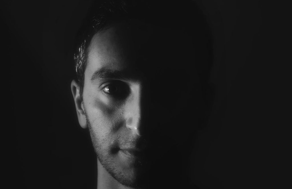 Italian DJ and producer Inve in a head shot in a darkened room, black and white image.