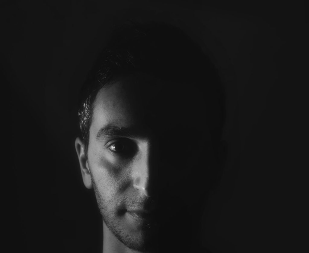 Italian DJ and producer Inve in a head shot in a darkened room, black and white image.
