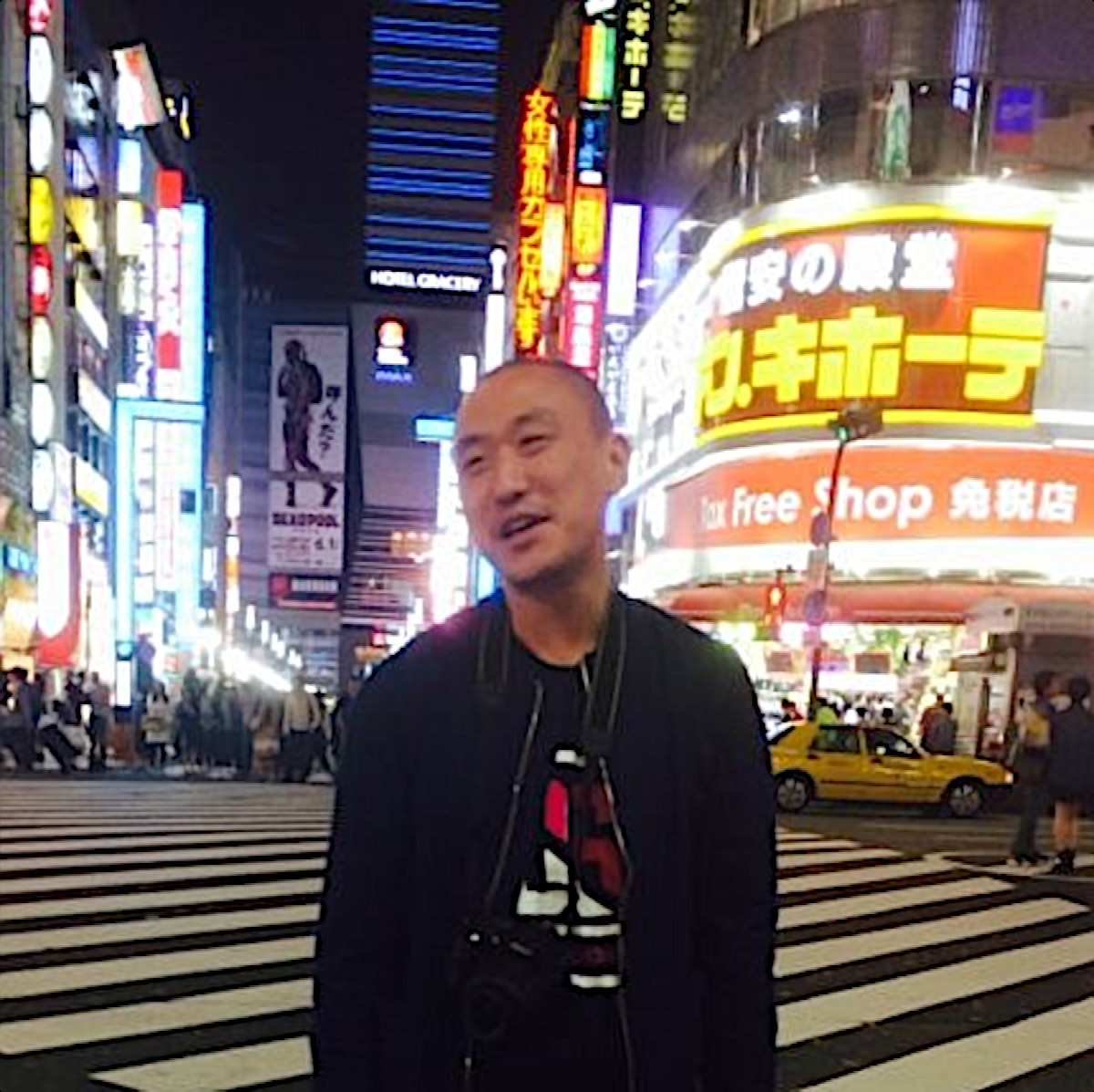 Taiwanese DJ and promoter Murphy Kin a.k.a Dj Lucy standing on a pedestrian crossing in Japan, colour image.