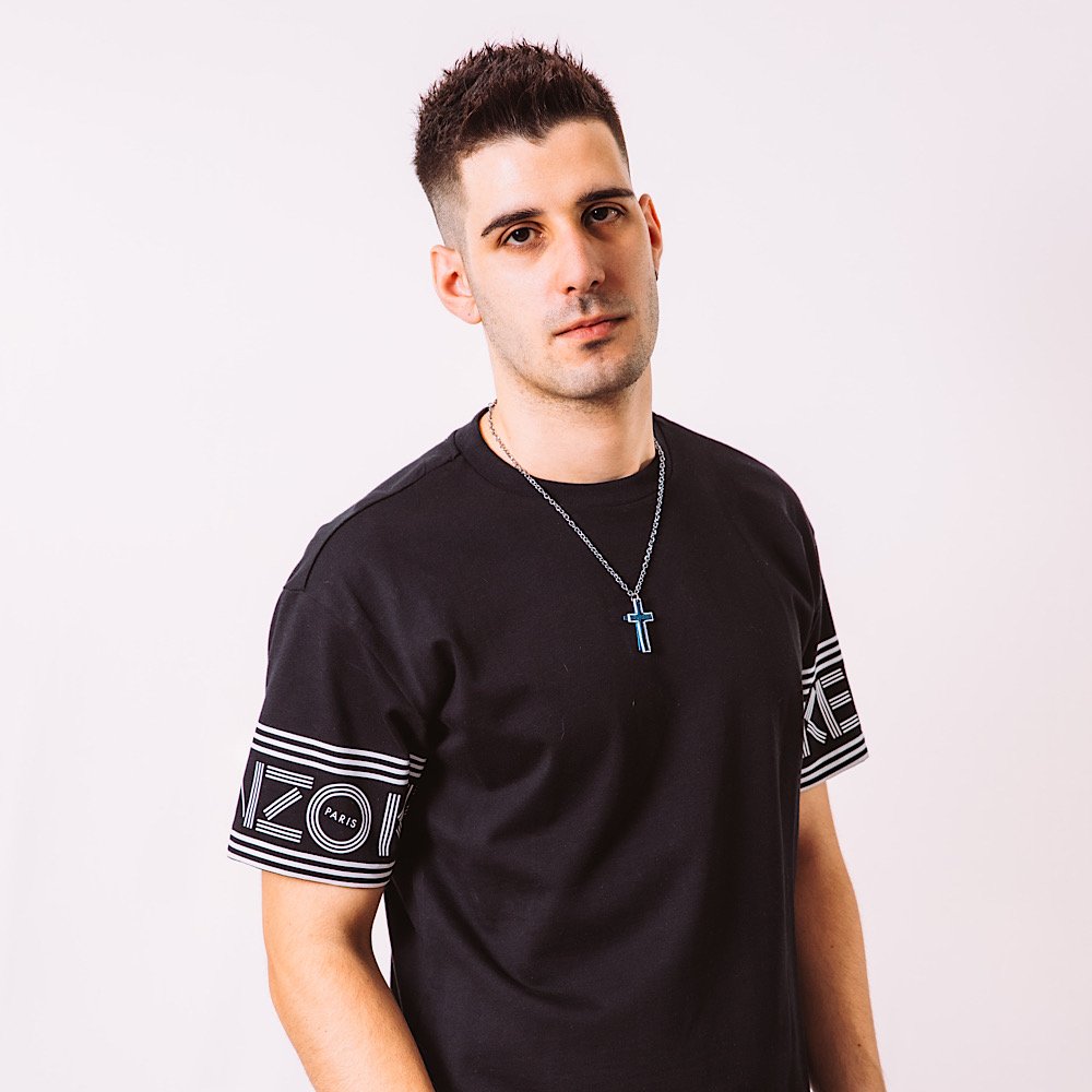 Italian DJ and producer Giorgio Leone stading in upper body shot with hands in his pockets, colour image.