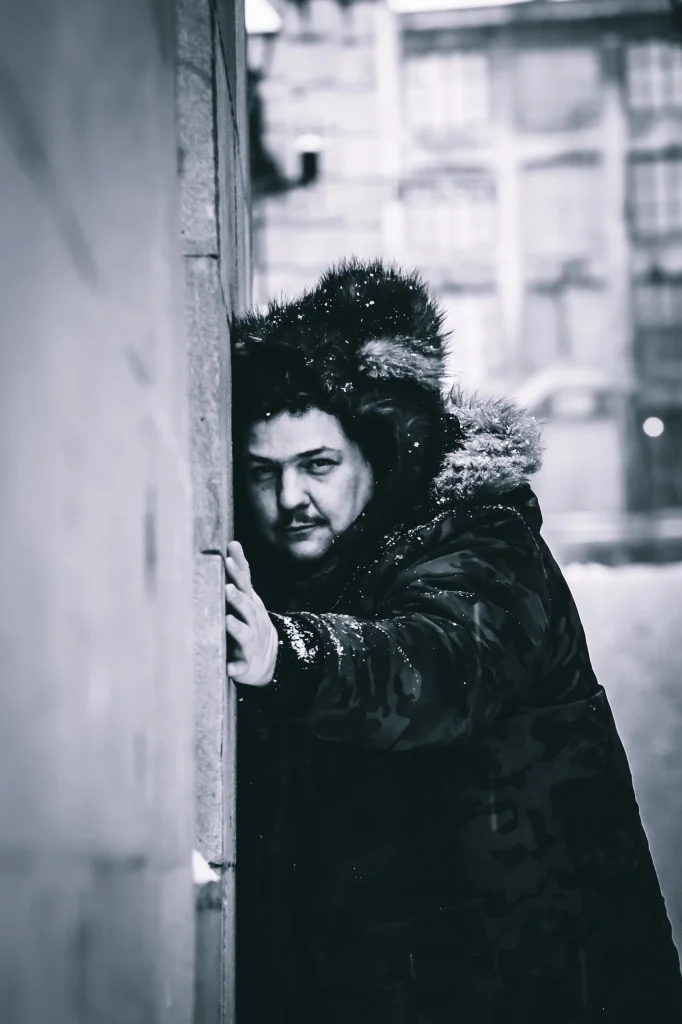 Black-and-white portrait of Canadian DJ Spiritual Viking, also known as Trevor Peterson, leaning against a wall in snowy weather, representing his Techno sound and Montreal club background.