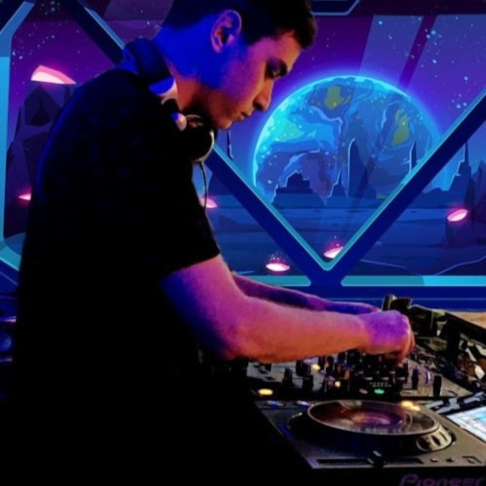 Argentinian DJ and producer Agustin Olmedo performing on Pioneer CDJs at event with spaceship background, colour image.