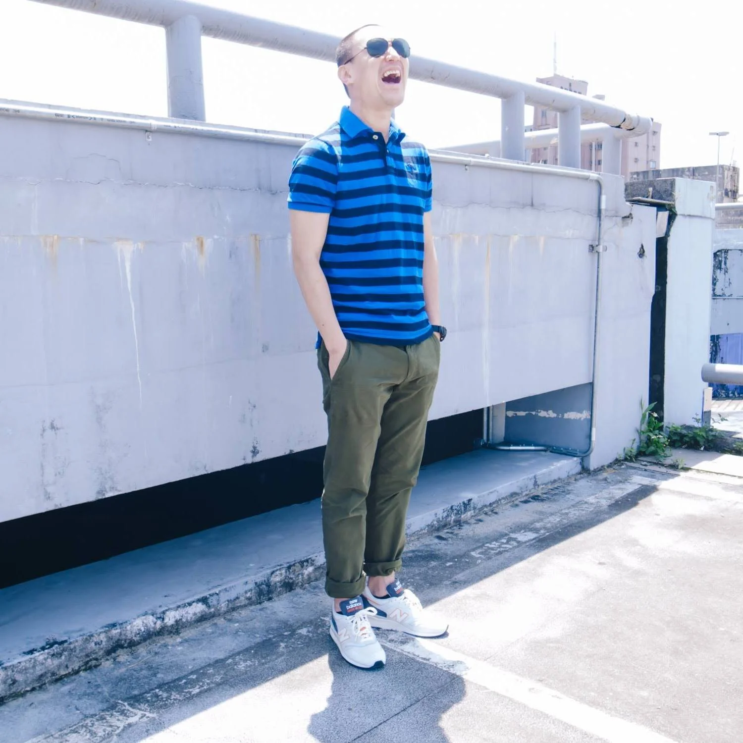 Taiwanese DJ and promoter Murphy Kin a.k.a Dj Lucy standing with his hands in his pockets and laughing, colour image.