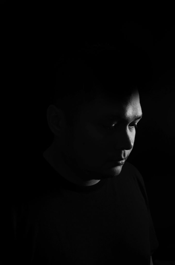 Indonesian DJ and producer Robin Rahardian of The House Cartel, posing in Dark room right side of face showing, image in black and white.