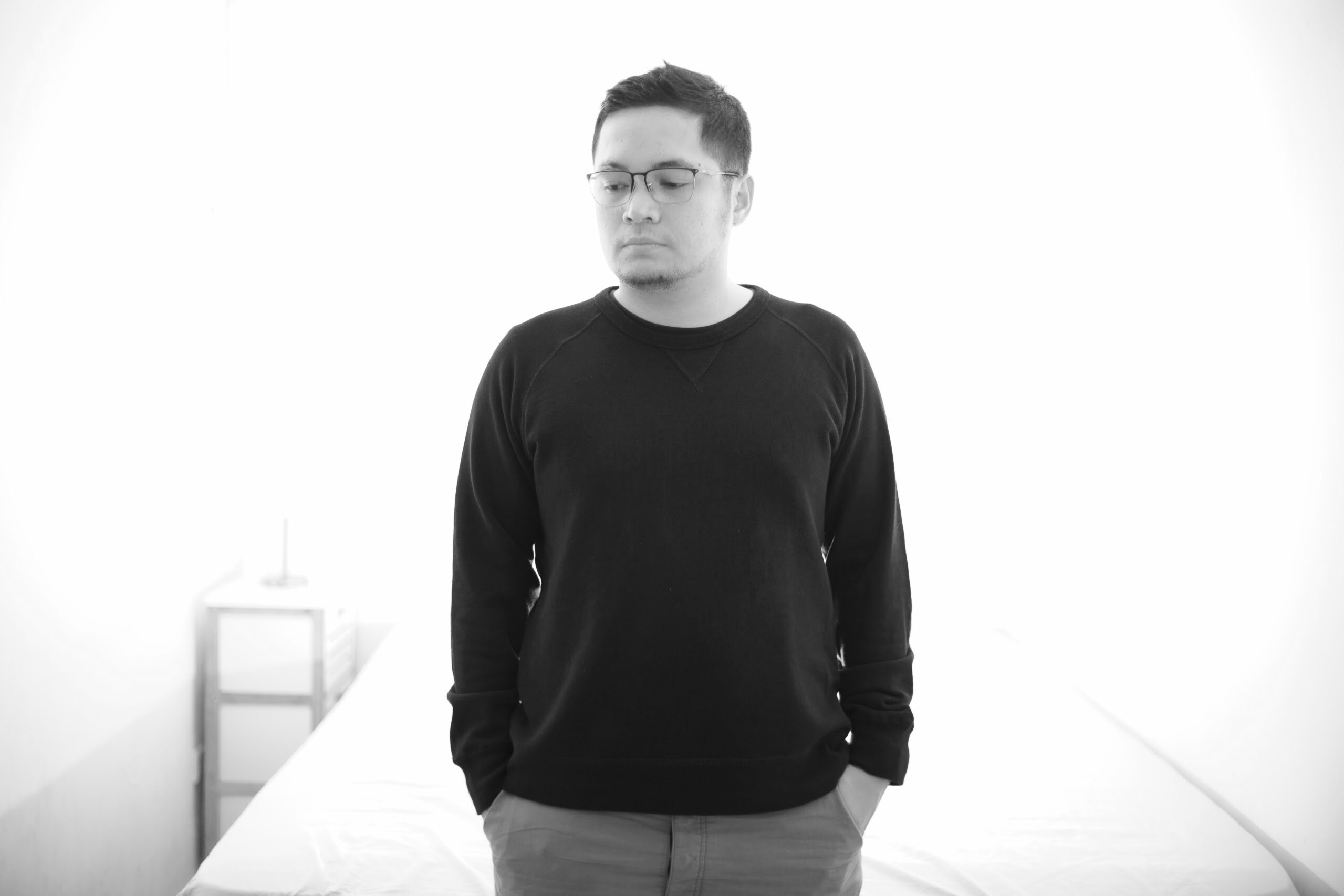 Indonesian DJ and producer Robin Rahardian standing with hands in pockets looking over to the right, image in black and white.