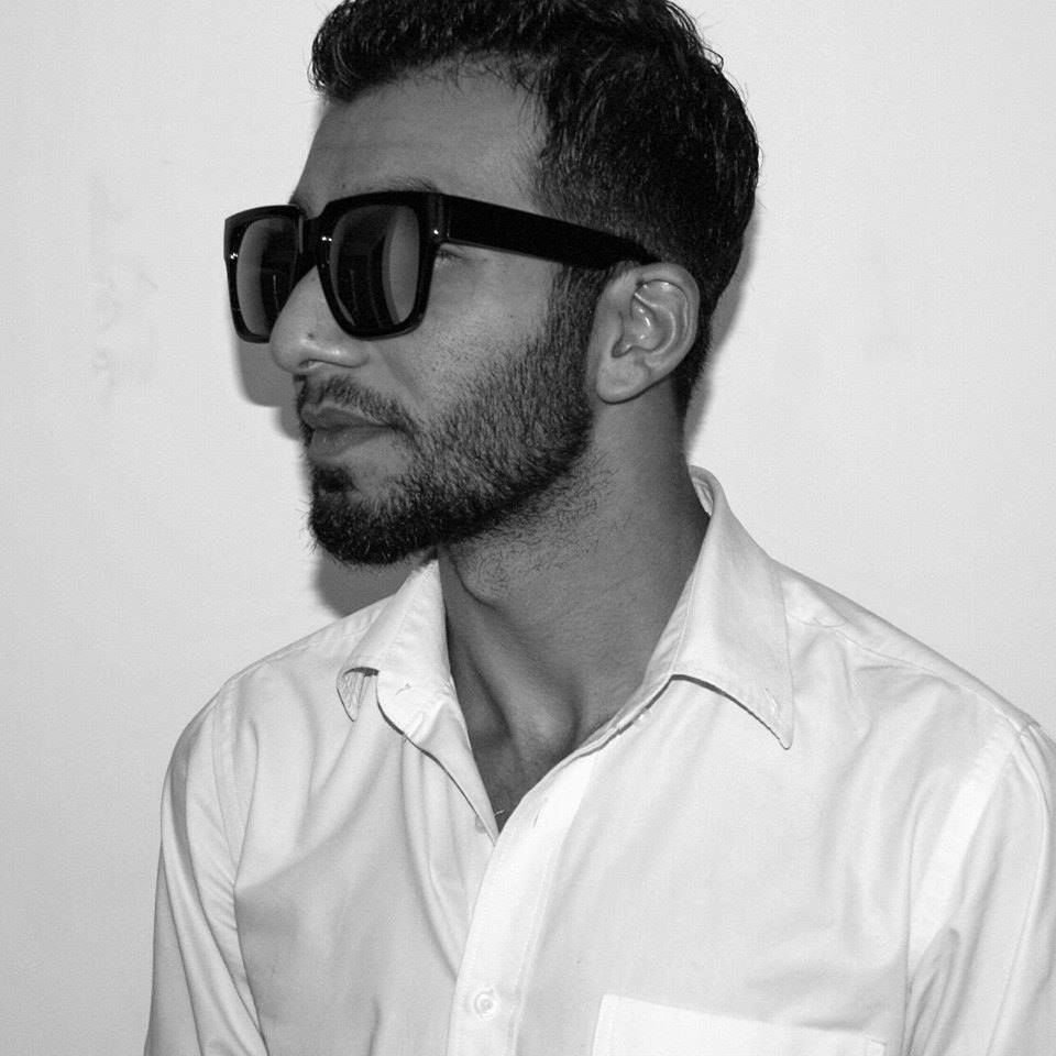 DJ Leo Standing at 45 degreesa to the right wearing sunglasses in Black and White.