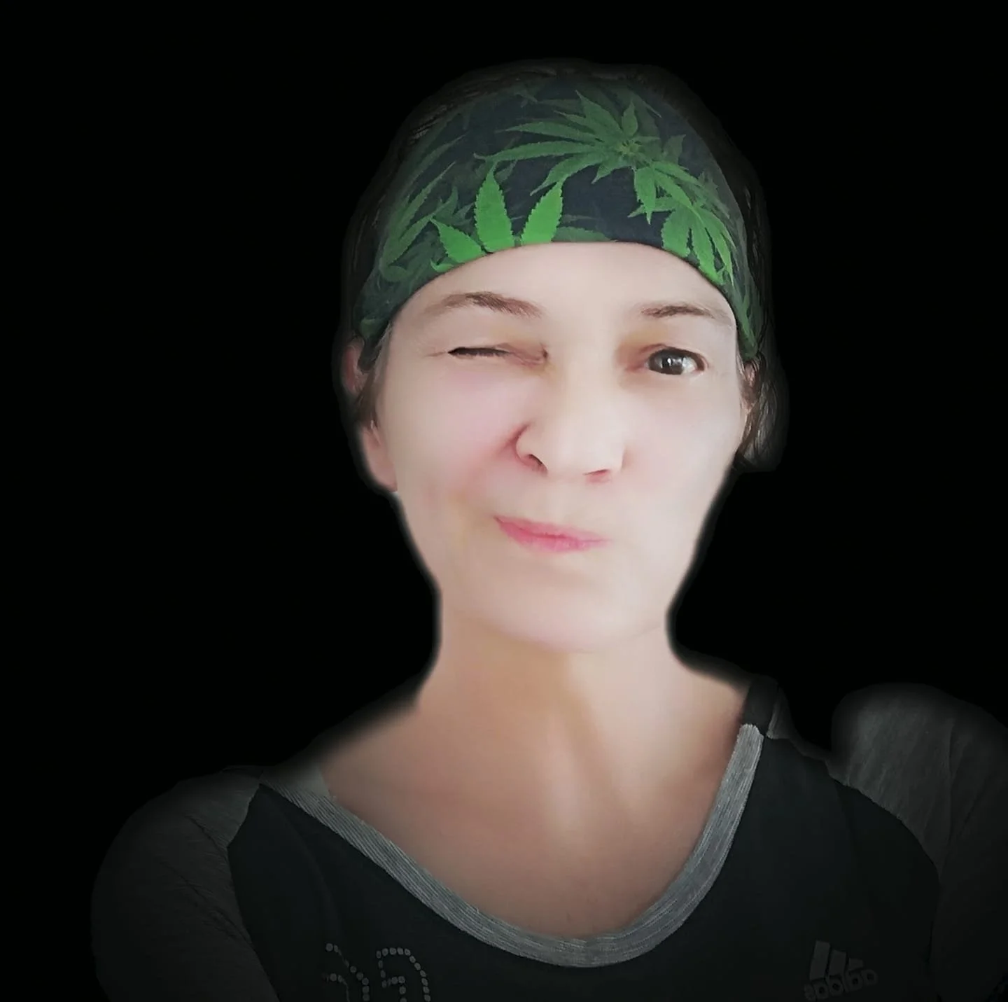 German DJ and promoter P.E.R.I. Winking at the camera with a headscarf on, colour image.