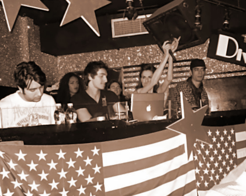 Italian DJ and producer INVE performing as a DJ at an event at the beginning of his career, black and white image with brown tinge.