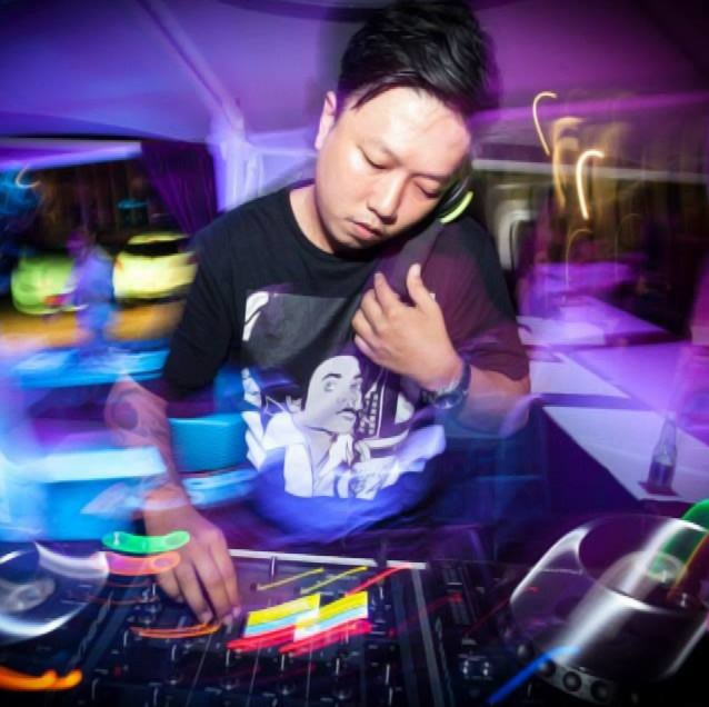 Thai DJ and producer Q Norongwate performing as a DJ at an event in Phuket, Thailand, colour image.