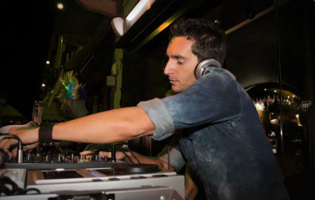 Italian DJ and producer INVE performing at an event as a DJ, side image in colour.