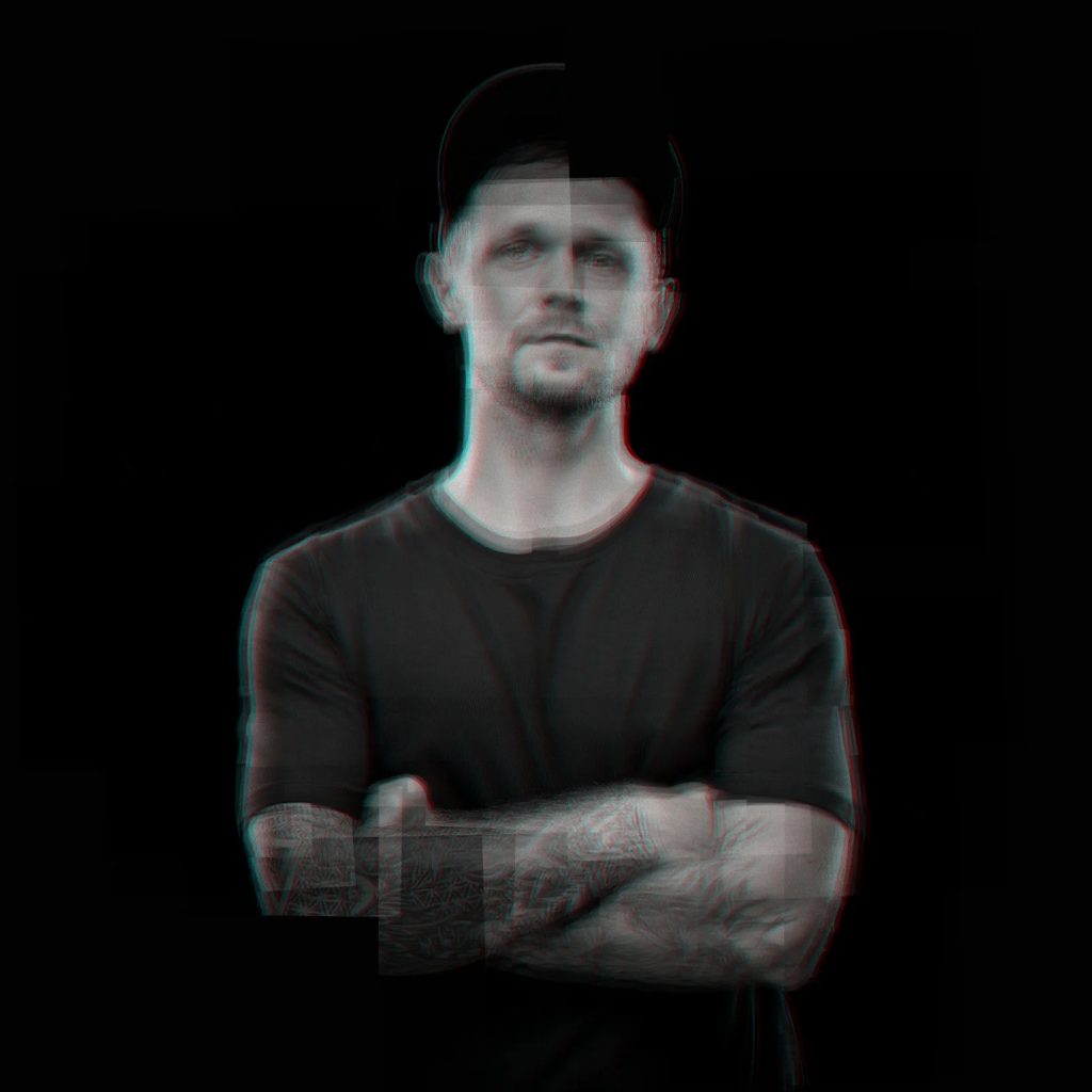 belarusian DJ Hush standing with arms crossed in blurred upper body picture, off colour.