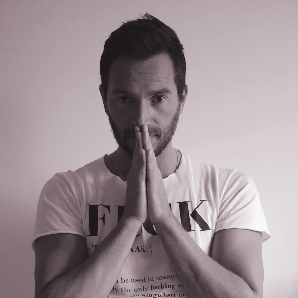 Italian DJ and producer INVE praying, black and white photo with purple tinge.