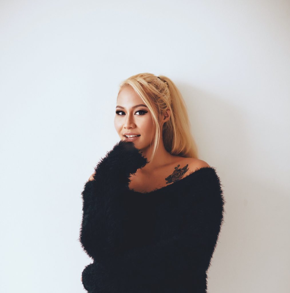 Malaysian DJ, Songwriter and producer Meliha standing smiling at camera with her hand on her chin, colour image