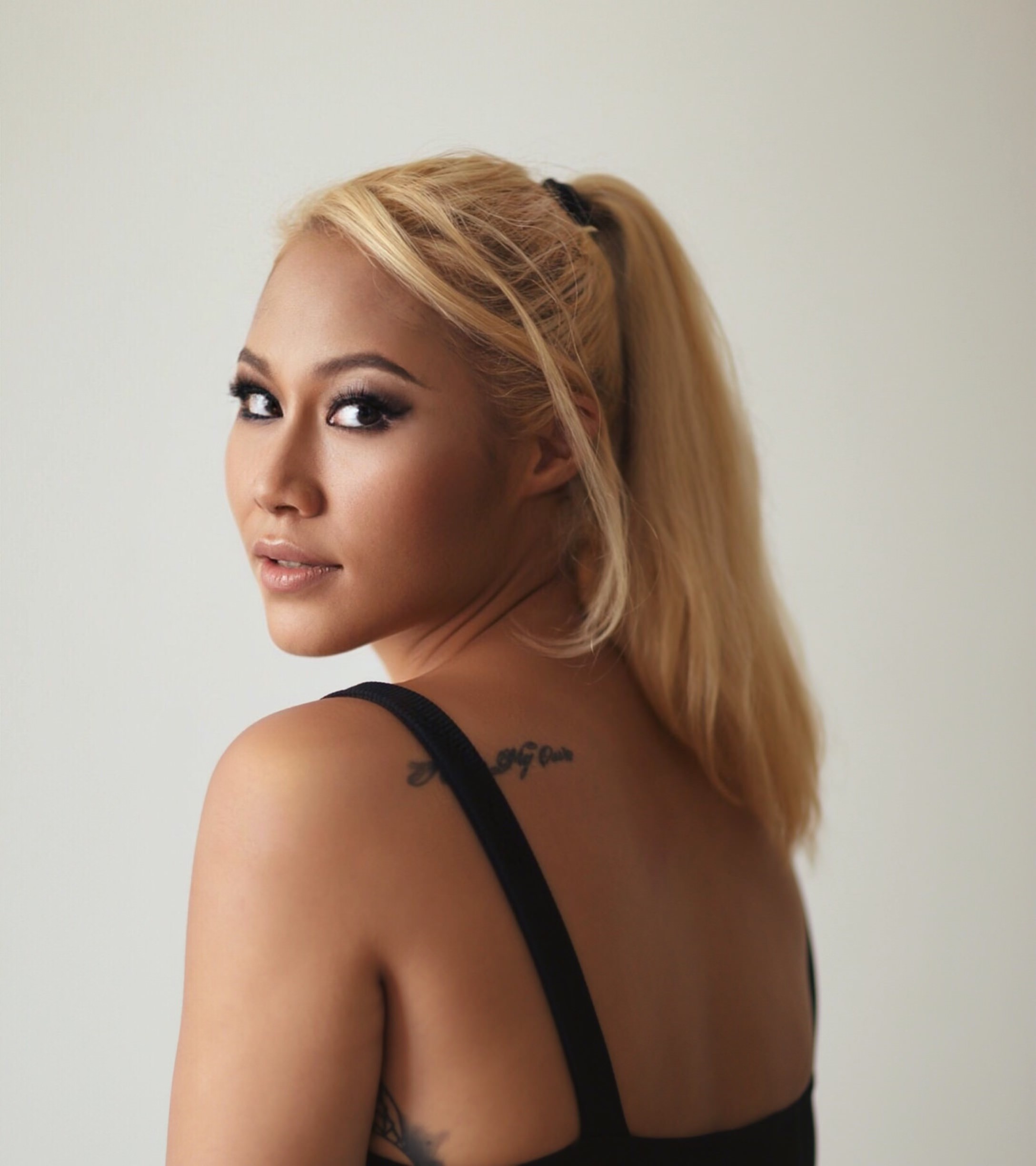 Malaysian DJ, Songwriter and producer Meliha stading looking over her left shoulder at the camera, colour image.
