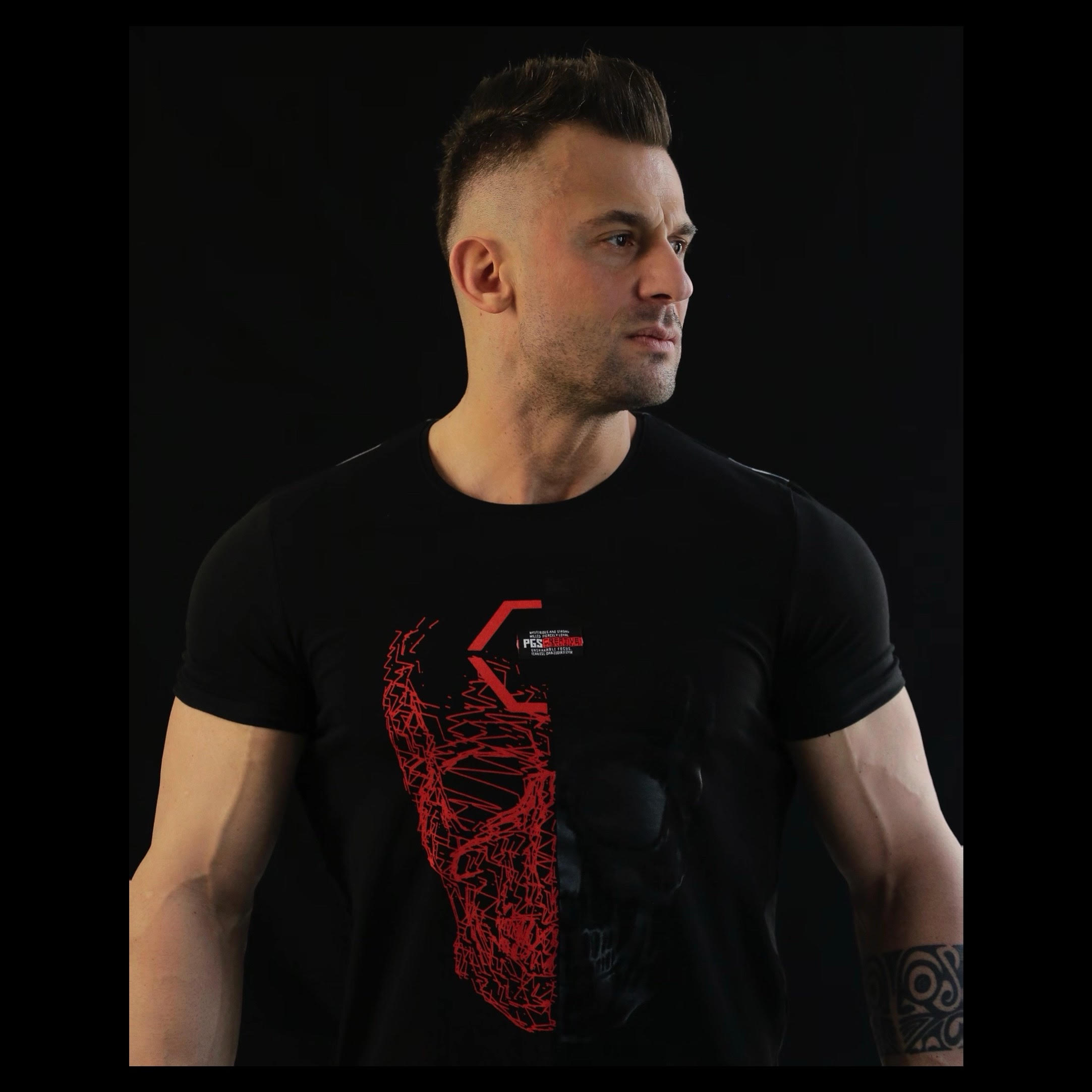 Turkish DJ and producer Fatih Şipka standing looking left, colour image.