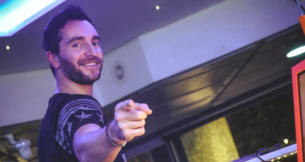 Italian DJ and producer INVE pointing his finger at the camera whilst performing at ibar, colour image.