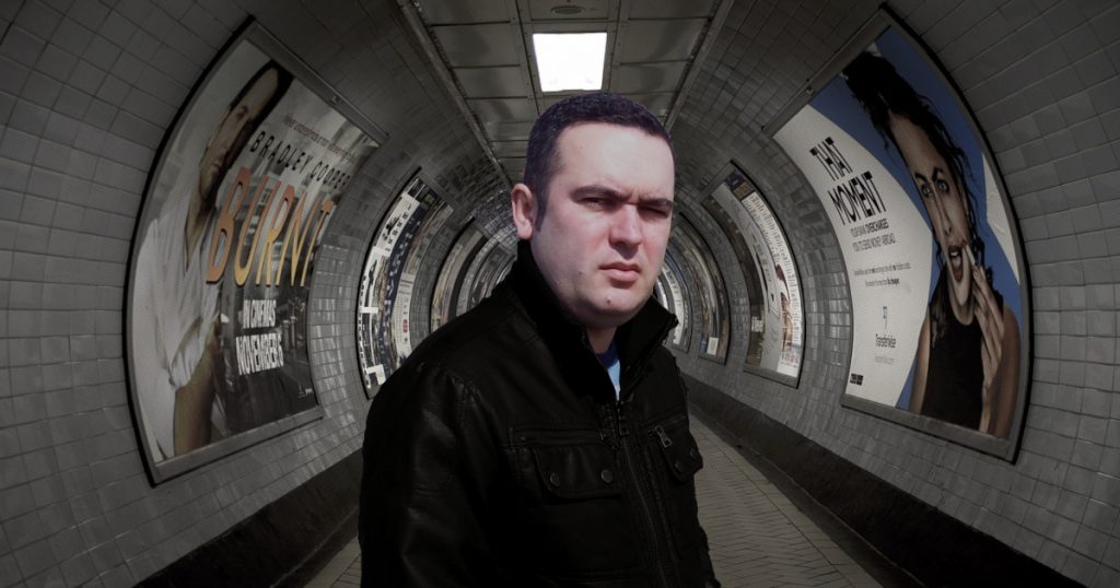 Portuguese DJ Joshua standing in a tunnel of the London Underground in the UK, colour image.