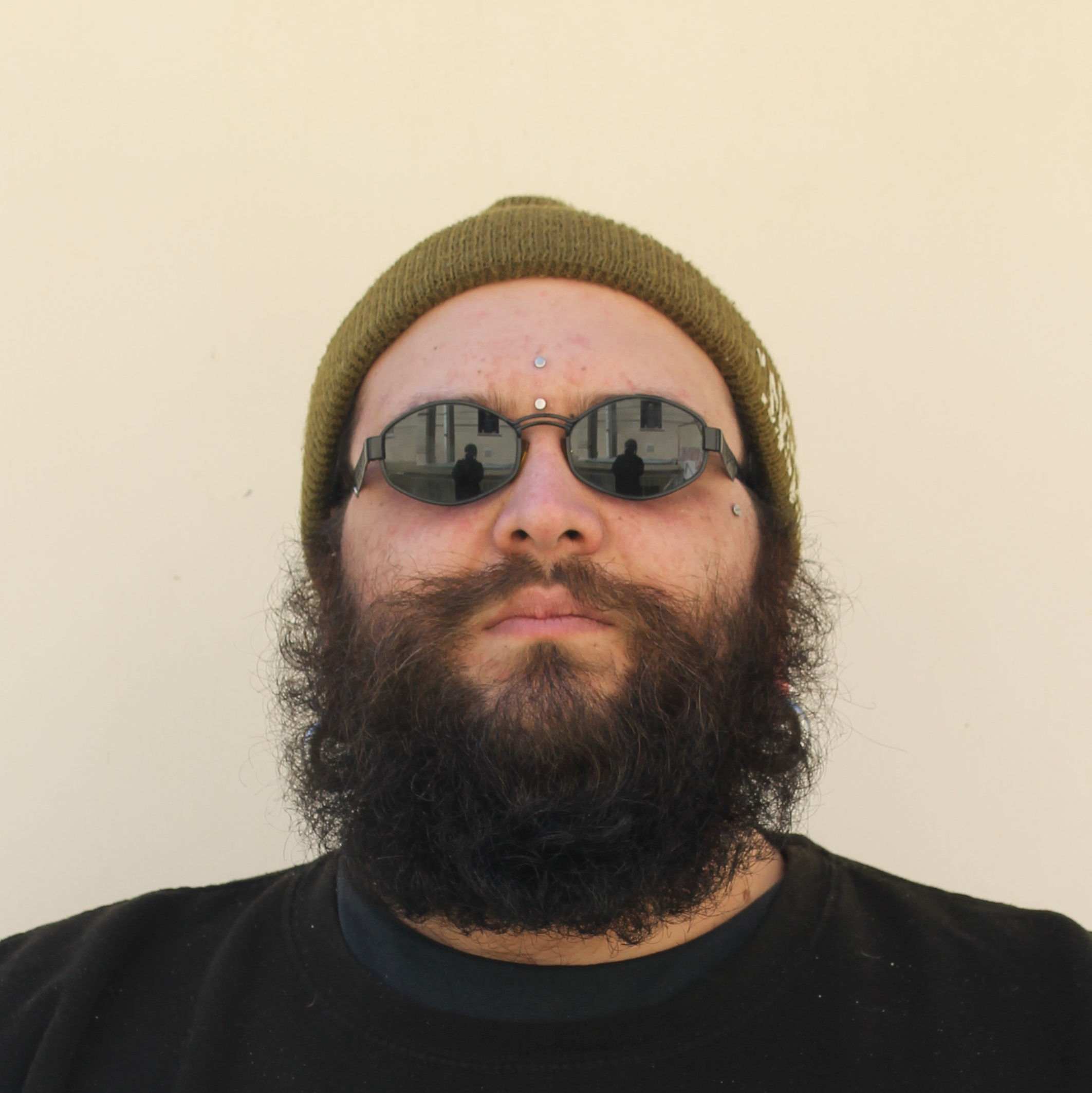Italian DJ No More Core standing wearing sunglasses, head shot, colour image.