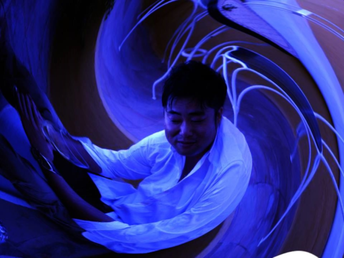 Japanese DJ and promoter DJ Marcy in a swirl shot in Black and white with a blue tinge.