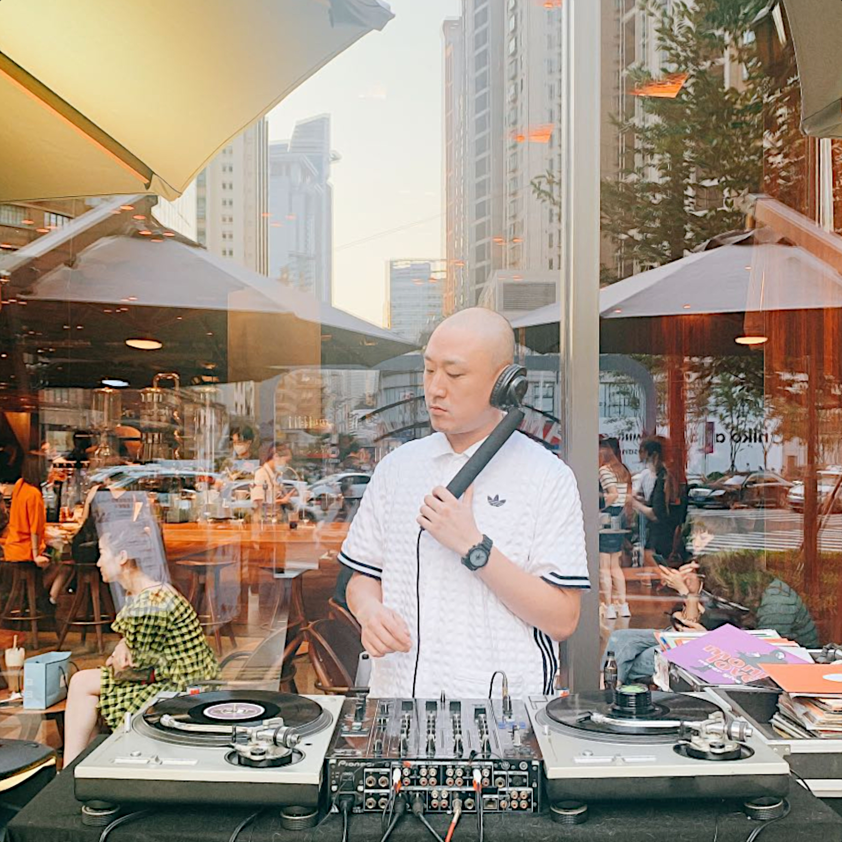 Taiwanese DJ and producer Murphy Kin performing at an event on Technics SL 1200s, colour image.