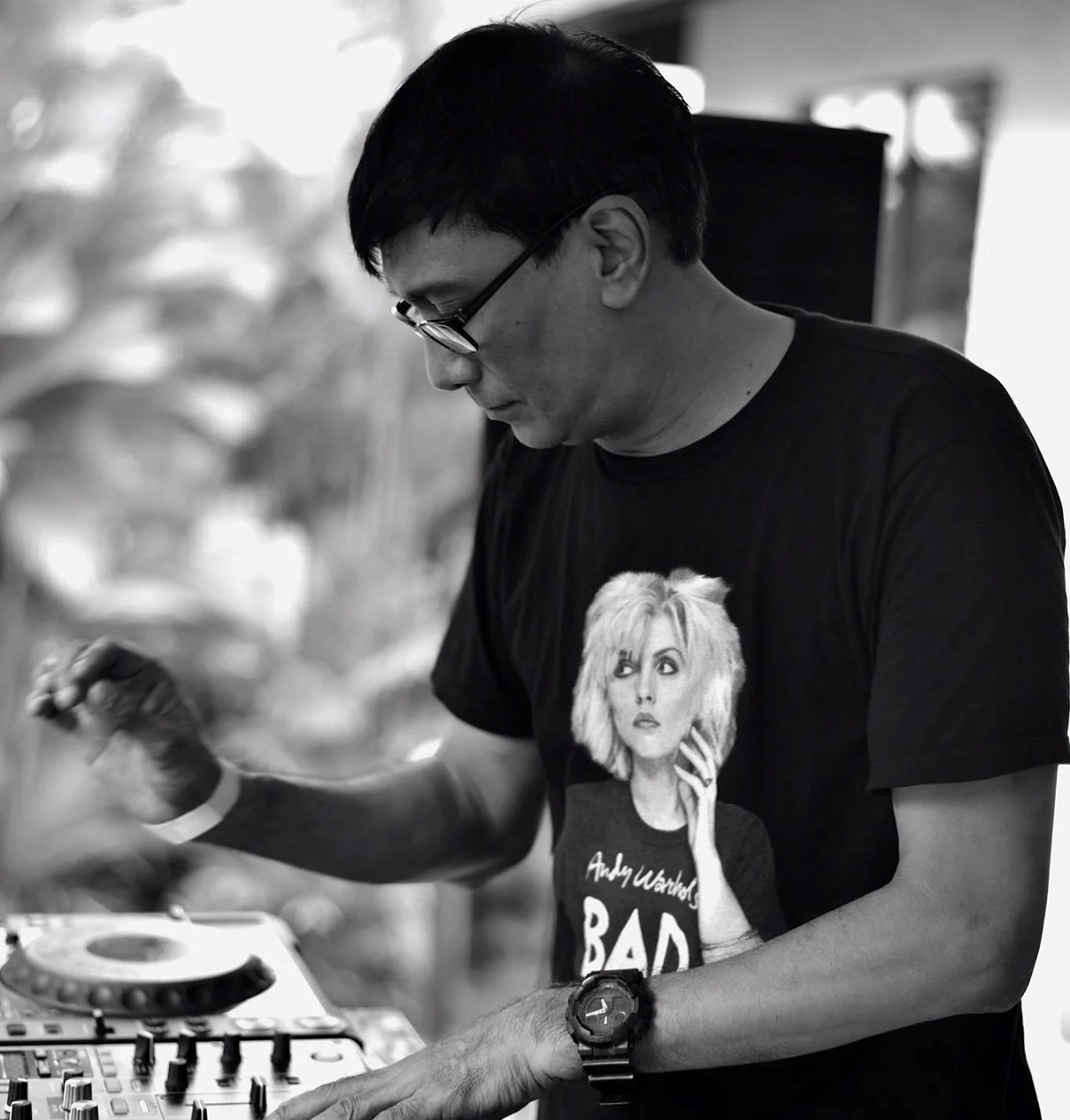 Singaporean DJ and producer Brendon P performing at an event wearing a Andy Worhul Bad T-shirt, black and white image.