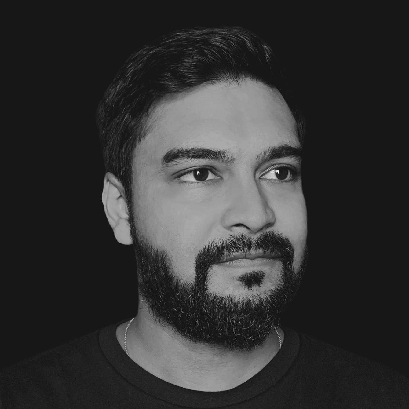 Indian DJ and producer LastOnStage standing looking to left of camera, black and white image.