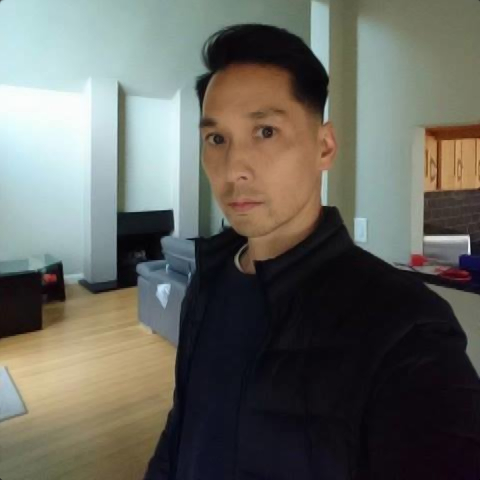 American DJ, producer and label owner Jerry Chiu standing looking at camera, colour image.