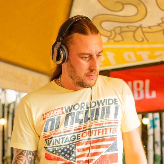 Belgian DJ, producer and AH Digital label co-owner PatriZe performing at an event wearing headphones, colour image.