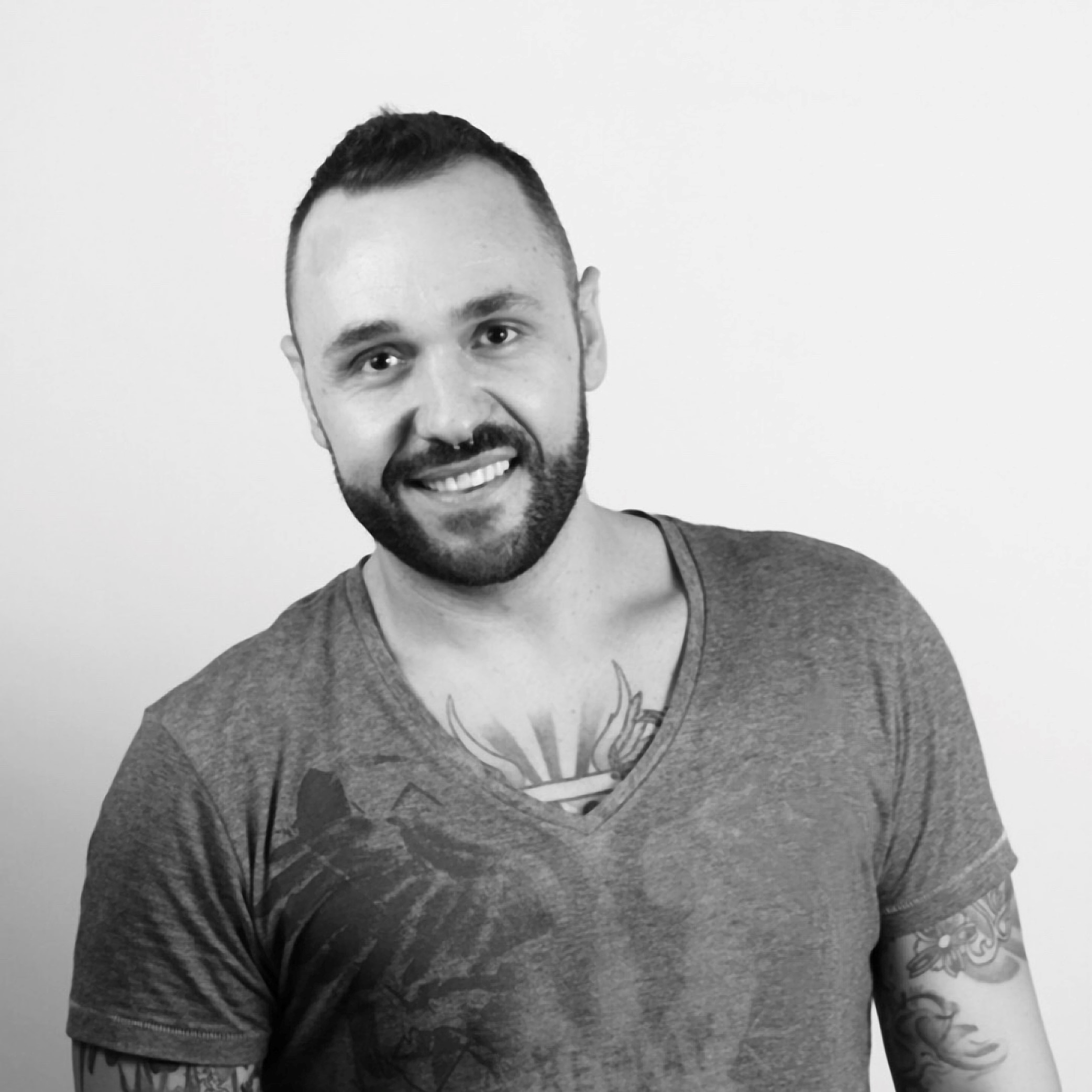 Spanish DJ and producer David Aarz standing smiling at camera, black and white image.